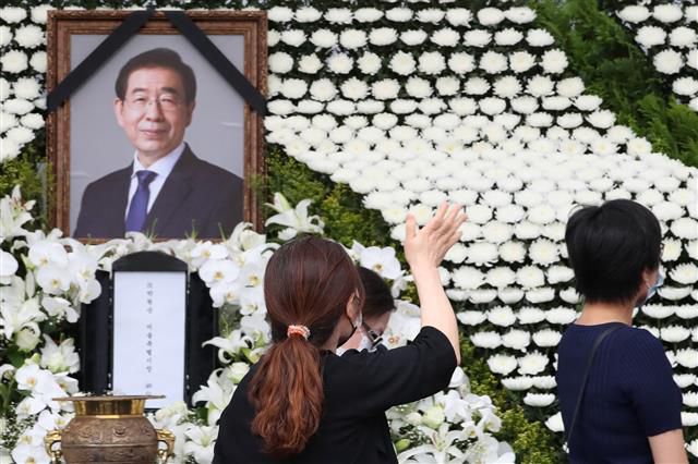 12일 오후 서울 중구 서울시청 앞 서울광장에 마련된 고(故) 박원순 서울특별시장 분향소에서 한 시민이 고인의 영정을 향해 손을 흔들어 인사하고 있다. 2020.7.12 뉴스1