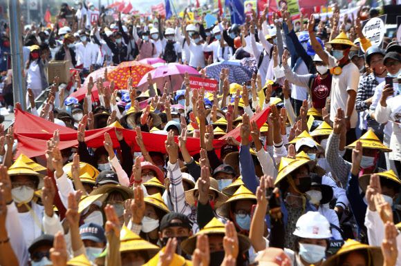 22일 미얀마 만달레이의 철도역 부근에서 열린 시위에서 시민들이 저항의 상징인 세 손가락 경례를 해보이고 있다. 2021년 2월 22일에 벌이는 시위라는 뜻에서 2를 5개 붙여 ‘22222 시위’로 불린 이날 시위는 미얀마 전역에서 열려 공무원과 은행 직원, 철도 근로자 등 쿠데타 이후 가장 많은 시민이 참여했다. 만달레이 AP 연합뉴스