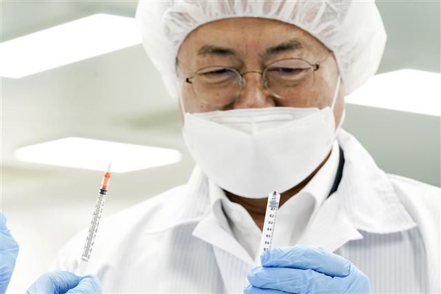 최소잔여형 주사기 살펴보는 문 대통령 - 문재인 대통령이 18일 오후 전북 군산시 코로나19 백신접종용 최소잔여형(LDS) 주사기 생산시설인 풍림파마텍을 방문해 일반 주사기와 최소잔여형 주사기 비교 시연을 하고 있다. 2021.2.18 뉴스1