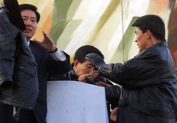 - 2002년 서울 여의도 한강 둔치에서 열린 농민대회에 참석해 연설을 하던 당시 민주당 노무현(가운데) 대통령후보가 한 농민이 던진 달걀을 맞고 입을 감싸고 있다. 서울신문 DB