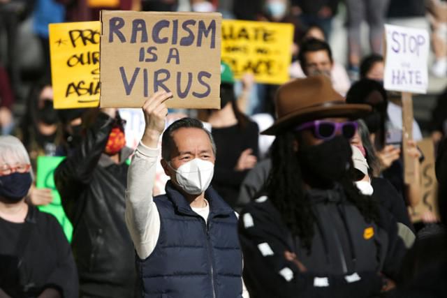 13일 미국 워싱턴주 시애틀에서 열린 인종차별 반대 집회에서 한 남성이 ‘인종차별은 바이러스’라고 적힌 팻말을 들고 있다. 사진=AFP 연합뉴스