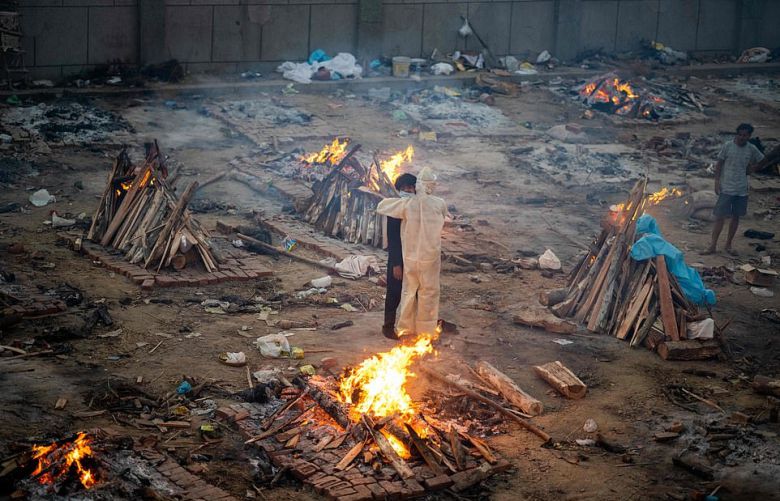 인도 대규모 화장장 한 가운데에 서 있는 사람들