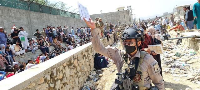 24일 아프간인 이송을 위해 한국 공군 수송기가 도착한 카불 공항 인근에서 우방국 병사가 한국 외교관과 함께 한국행 아프간인을 찾고 있는 모습.외교부 제공