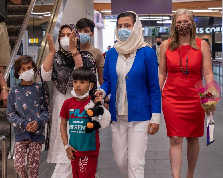 무늬가 들어간 검은색 스카프를 쓴 수니타와 그녀의 네 자녀의 모습. 이들 가족의 오른쪽에는 빨간색 원피스 차림의 세라 라우리 변호사가 서 있다.