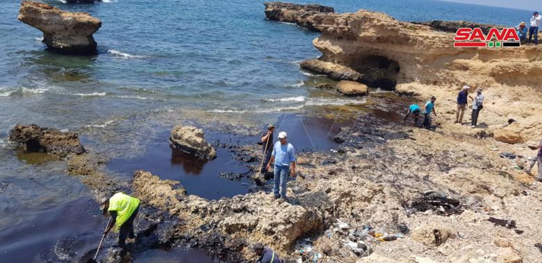 시리아 바니야스 해안에서 기름 제거 작업에 열중하는 주민들