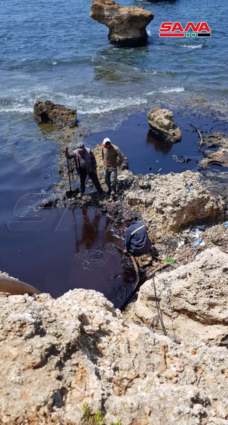 시리아 바니야스 해안에서 기름 제거 작업에 열중하는 주민들