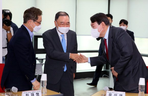 국민의힘 정홍원 선거관리위원장(가운데)이 5일 서울 여의도 국민의힘 중앙당사에서 열린 공정경선 서약식 및 선관위원장 경선 후보자 간담회에서 윤석열, 최재형 후보와 악수하며 입장하고 있다. 홍준표, 유승민, 하태경, 안상수 후보는 ‘역선택 방지조항 제외’를 주장하며 이날 행사에 불참했다. 2021.9.5 연합뉴스