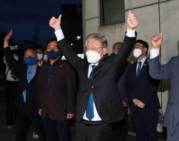 더불어민주당 대선주자인 이재명(오른쪽) 경기지사가 26일 전북 완주 우석대 체육관에서 열린 민주당 대선 후보 선출을 위한 합동연설회에서 전북 지역 경선 승리를 확인한 후 엄지손가락을 들어 지지자들의 환호에 답하고 있다. 완주 연합뉴스