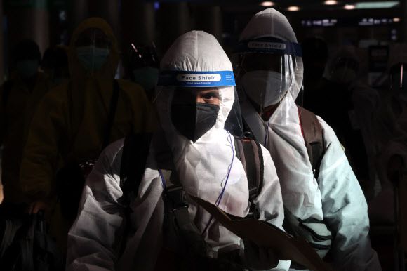 29일 오전 방호복을 입은 해외 입국자들이 인천국제공항을 통해 입국하고 있다. 방역 당국은은 새로운 코로나19 변이 바이러스인 ‘오미크론’의 국내 유입 차단을 위해 남아프리카 8개국에서 오는 외국인을 입국금지 조처했으며, 향후 대상 국가를 확대하는 방안을 검토할 방침이다. 2021.11.29 연합뉴스