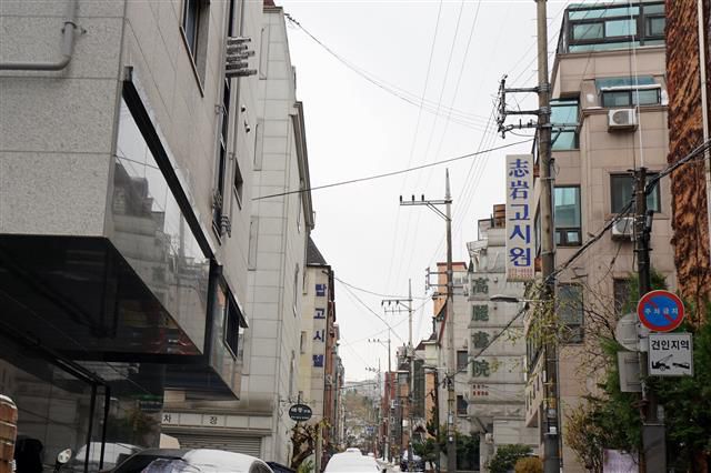 대학생 30~40명이 묵던 하숙집, 층별 남녀구별 화장실 및 공동 샤워실을 갖춘 다세대주택, 전문화된 고시원, 필로티로 띄어진 원룸빌딩 등이 혼재된 대학동 고시촌 골목의 풍경.