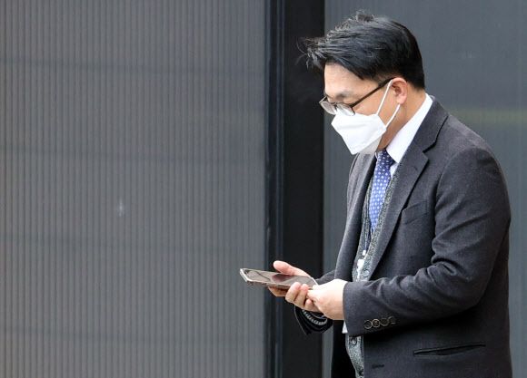 휴대전화 보는 김진욱 처장 - 김진욱 고위공직자범죄수사처(공수처) 처장이 29일 정부과천청사 공수처 건물을 나서며 휴대전화를 보고 있다. 한 시민단체는 공수처가 기자 등 민간인을 대상으로 통신자료를 조회했다는 논란과 관련해 지난 23일 김 처장을 직권남용권리행사방해 등의 혐의로 고발했다.연합뉴스