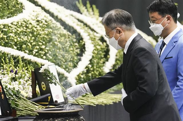 순직 소방관 합동영결식 헌화하는 문대통령 - 문재인 대통령이 8일 오전 경기도 평택시 이충문화체육센터에서 엄수된 경기도 순직 소방공무원 합동영결식에서 헌화하고 있다. 청와대 제공 2022.1.8