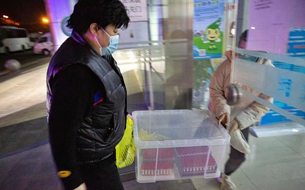 15일 밤 중국 베이징시 하이뎬구 주민 검체를 운반하는 방역당국 직원들.