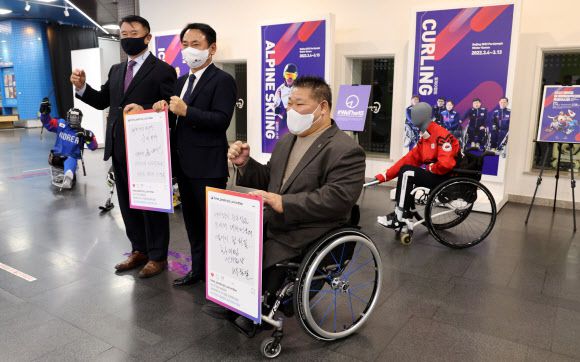 윤경선(가운데) 베이징동계패럴림픽 선수단장이 14일 서울 시민청에서 열린 기자간담회에서 박종철(왼쪽) 선수촌장과 신영용 선수단 부단장과 함께 파이팅을 외치고 있다.연합뉴스