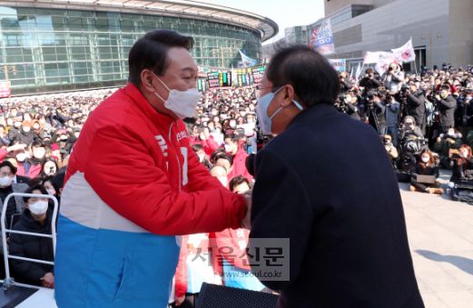 제20대 대통령 공식 선거운동 시작일인 15일 오후 대구 동구 동대구역광장에서 윤석열 국민의힘 대선 후보 거점유세에 앞서 홍준표 의원이 윤 후보 지지연설에 앞서 악수를 하고 있다. 윤 후보는 이날 오전 국립서울현충원을 참배한 뒤 청계광장에서 출정식 갖고 대전과 대구, 부산 등을 돌며 22일간의 대장정에 돌입한다. 2022. 2. 15 김명국 선임기자