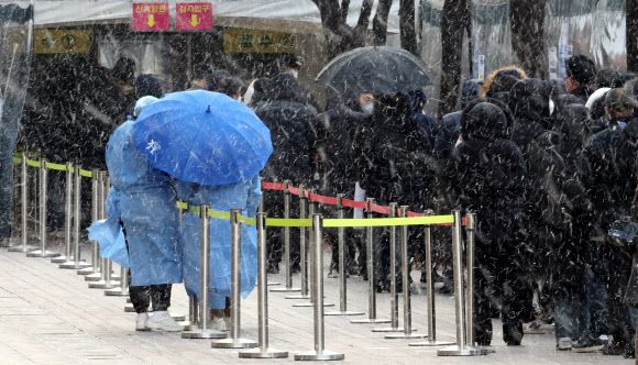 눈발 추위, 오미크론발 확산 - 눈발과 추위가 찾아온 15일 서울광장 선별진료소에서 시민들이 검사를 기다리고 있다. 이날 0시 기준 신규 확진자는 5만7천177명이다. 2022.2.15 연합뉴스