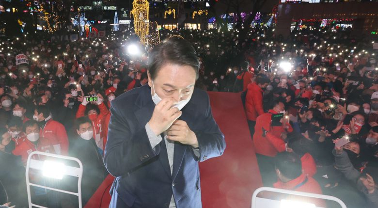 윤석열 국민의힘 대선 후보가 19일 오후 경남 창원시 상남분수 광장에서 열린 유세에서 지지자들에게 인사한 뒤 마스크를 고쳐쓰고 있다. 2022.2.19 공동취재.