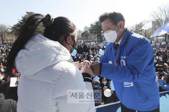 이재명 더불어민주당 대선후보가 20일 오후 경기 안양중앙공원에서 열린 “’안양’하세요, 이재명과 발전하는 경기 남부!” 유세에서 시민에게 호루라기를 선물 받은 뒤 주먹인사를 하고 있다.2022. 2. 20 정연호 기자