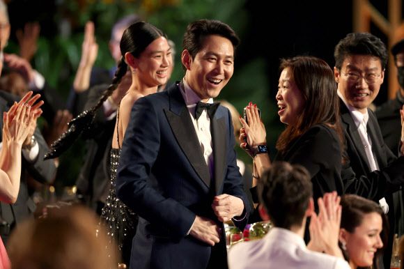 - ‘오징어 게임’의 이정재(가운데)가 27일(현지시간) 미국 로스앤젤레스 샌타모니카에서 열린 제28회 미국배우조합상 시상식에서 TV 드라마 남우주연상에 호명된 뒤 기뻐하고 있다. 왼쪽은 여우주연상을 받은 정호연, 맨 오른쪽은 황동혁 감독.로스앤젤레스 게티/AFP 연합뉴스
