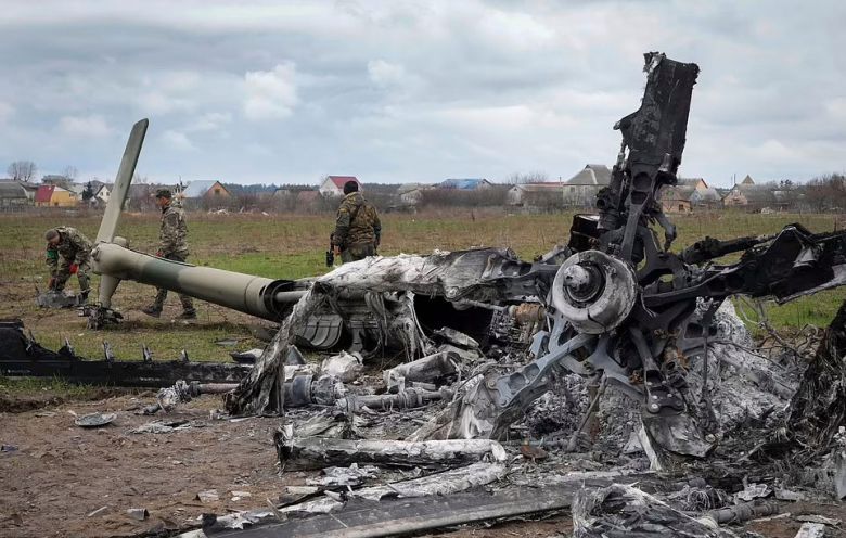 우크라이나 수도 키이우 외곽 호스토멜의 한 공항에서 지난 18일(현지시간) 우크라이나군 공병이 파괴된 러시아군 헬기 잔해 옆 불발탄을 수색하고 있다. / AP 연합뉴스
