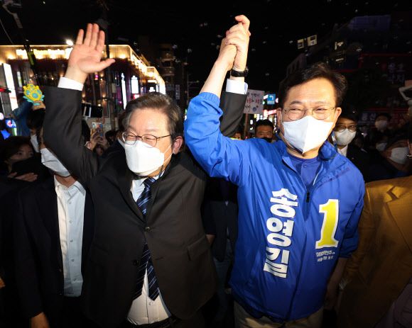손 맞잡은 이재명-송영길 - 인천 계양을 국회의원 보궐선거에 출마한 이재명 더불어민주당 상임고문과 송영길 서울시장 후보가 16일 오후 서울 마포구 홍대 앞에서 시민들과 만나기에 앞서 손을 맞잡고 있다. 2022.5.16 연합뉴스