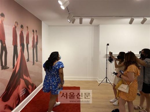 29일(현지시간) 미국 워싱턴DC의 한국문화원에서 한류 문화 전시가 열린 가운데 참가자들이 BTS 사진을 배경으로 기념 촬영을 하고 있는 모습.워싱턴 이경주 특파원