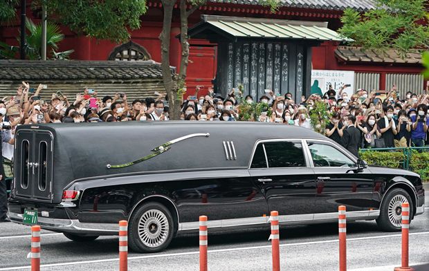 아베 신조 전 일본 총리의 시신을 실은 운구차가 12일 시민 배웅 속에 도쿄 내 사찰 ‘조조지’를 떠나고 있다. AP 연합뉴스