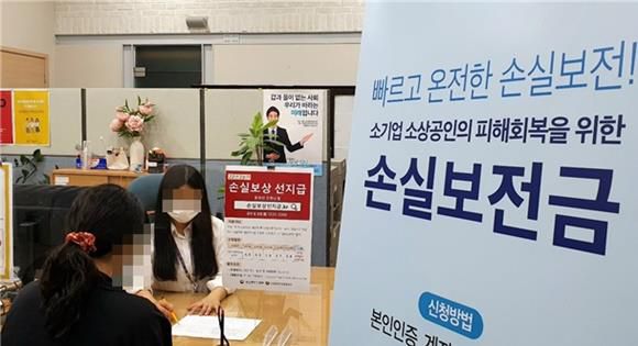 소상공인시장진흥공단의 서울중부지역센터에서 직원이 한 소상공인에게 코로나19 위기 극복을 위한 손실보전금에 대해 설명하고 있다.소진공 제공