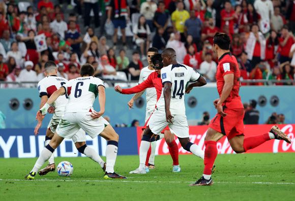 - 3일 오전(한국시간) 카타르 알라이얀의 에듀케이션 시티 스타디움에서 열린 2022 카타르 월드컵 조별리그 H조 3차전 대한민국과 포르투갈 경기. 포르투갈 수비에 둘러싸인 손흥민이 옆에서 쇄도하는 황희찬을 향해 어시스트하고 있다. 2022.12.3 연합뉴스