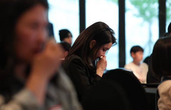 김건희 여사가 13일 서울 여의도 63컨벤션센터에서 열린 국가보훈처의 전몰·순직군경 자녀 지원 프로그램인 ‘히어로즈 패밀리 프로그램’ 출범식에서 시민 목숨을 구하려다가 순직한 고(故) 유재국 경위 배우자의 편지 낭독을 들으며 눈물을 흘리고 있다.  2023.4.13 연합뉴스(대통령실 제공)