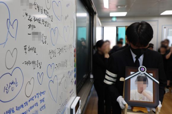 악성민원으로 세상을 뜬 대전 초등 교사의 유족들이 9일 오전, 교사가 재직하던 유성구 한 초등학교 교실에 영정사진을 들고 들어서고 있다. 2023.9.9 연합뉴스