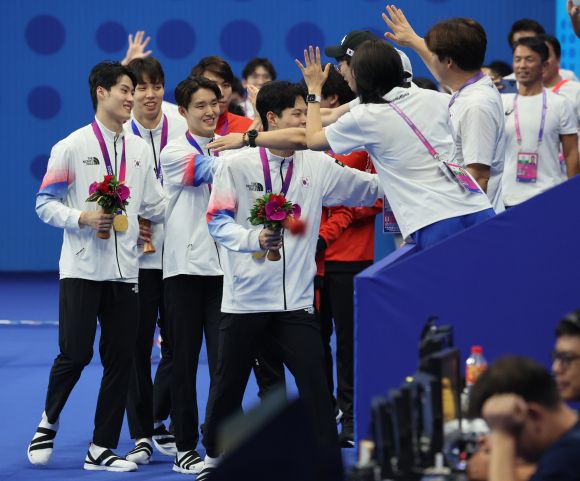대한민국 남자 800m 계영 메달 쾌거 - 양재훈, 이호준, 김우민, 황선우가 25일 중국 항저우 올림픽 스포츠센터 수영장에서 열린 2022 항저우 아시안게임 수영 남자 800m 계영 결승 시상식에서 금메달을 획득한 뒤 코치진의 격려를 받고 있다. 2023.9.25 항저우 연합뉴스