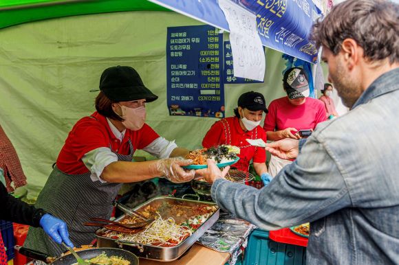 지난 22일 서울 마포구 월드컵공원에서 열린 제16회 마포나루 새우젓축제에서 한 방문객이 다회용기에 담긴 음식을 구매하고 있다. 마포구 제공