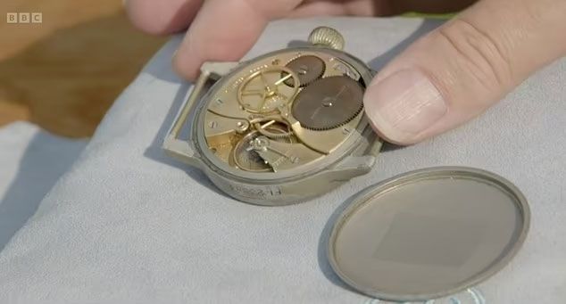시계 감정사가 한 여성 게스트가 가지고 나온 시계의 뒷판을 열고 무브먼트 등 시계 부품을 살피고 있다. / 사진=BBC