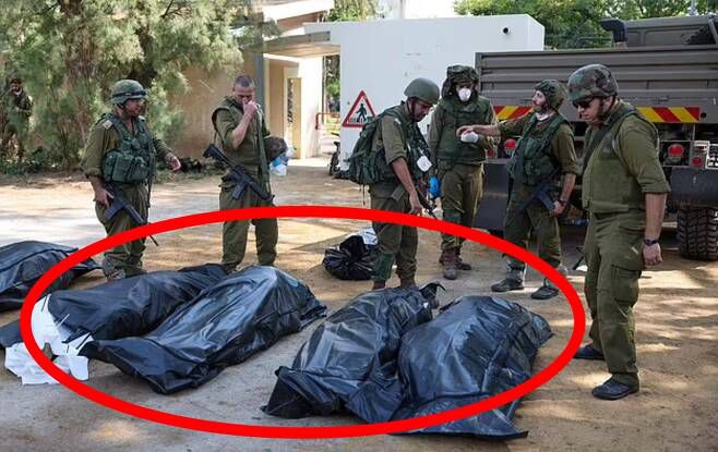 지난달 7일 팔레스타인 무장정파 하마스의 기습 공격으로 가장 큰 피해를 입은 이스라엘 남부 베에리 키부츠에서 이스라엘 군인들이 하마스에 의해 목숨을 잃은 주민들의 시신을 수습하고 있다. 로이터 연합뉴스