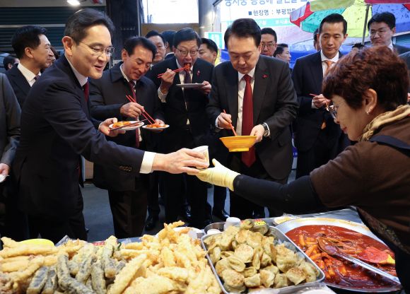 이재용 삼성전자 회장이 6일 부산 중구 깡통시장에서 윤석열 대통령과 함께 분식을 맛보던 중 상인으로 부터 어묵 국물을 받고 있다.  2023.12.6 연합뉴스