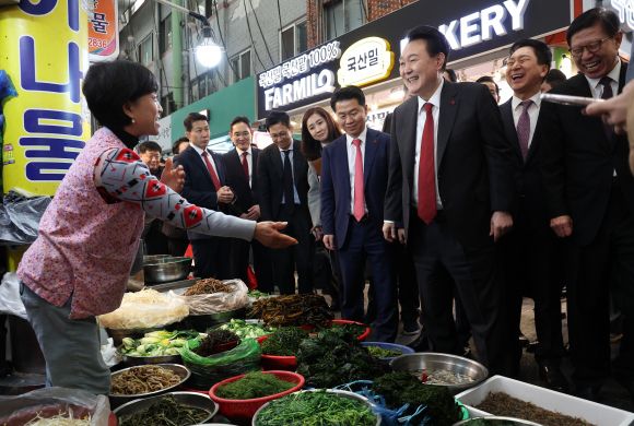 윤석열 대통령이 6일 부산 중구 깡통시장에서 나물가게 상인과 웃으며 대화하고 있다. 2023.12.6 연합뉴스