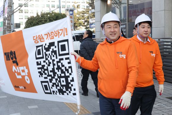 이준석(오른쪽) 개혁신당 대표와 김용남 정책위의장이 26일 국회의사당 앞 가로수에 정당 정책 홍보 현수막을 달기 위해 걸어가고 있다. 2024.1.26 연합뉴스