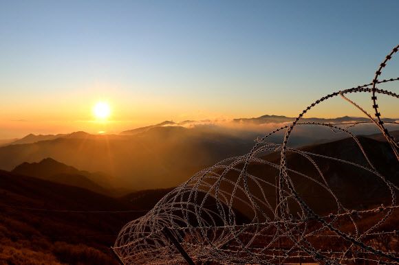 1일 오전 강원 인제군 서화면 향로봉에서 군 철책선 너머로 해가 힘차게 떠오르고 있다. 2023.1.1 인제군 제공