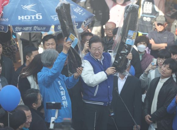 이재명 대표 ‘미역은 기장미역이지’ - 이재명 더불어민주당 대표가 15일 오후 부산 기장군 기장시장에서 기장미역을 들어보이고 있다. (공동취재) 2024.3.15/뉴스1