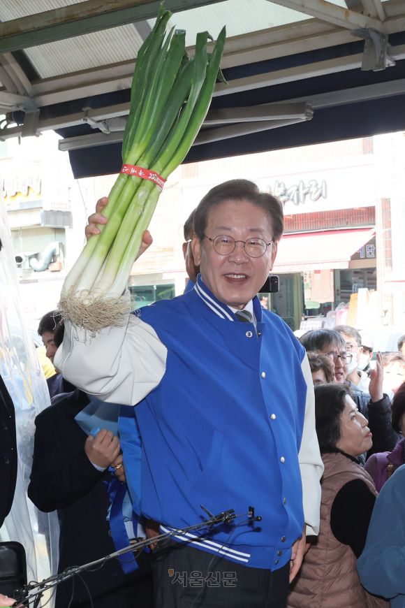 이재명 더불어민주당 대표가 27일 충북 제천시 동문시장을 찾아 시민들과 대화를 나누며 대파를 들어보이고 있다. 2024.03.27 제천 오장환 기자