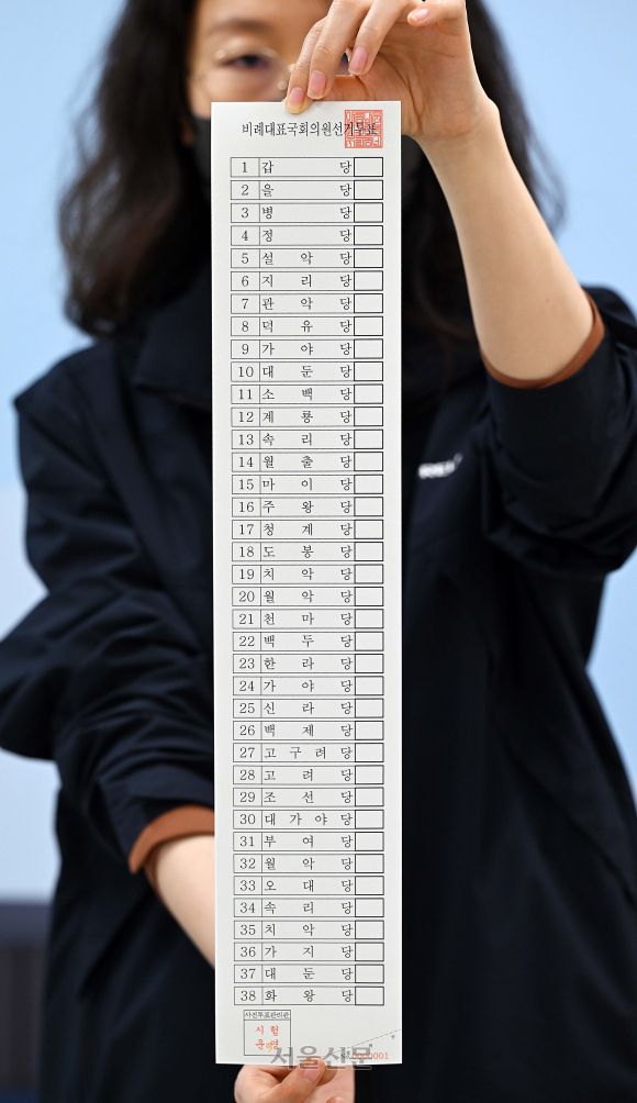 오는 4월 10일 실시되는 제22대 총선을 보름 앞둔 26일 서울 종로구 서울시선거관리위원회에서 선관위 직원들이 51.7㎝나 되는 비례대표 모의 투표용지를 들어 보이고 있다. 2024.3.26 홍윤기 기자