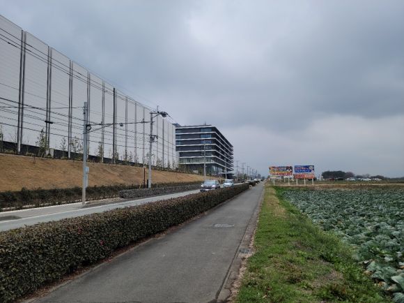 TSMC 공장 전경 - 지난 2월 20일 일본 구마모토현 기쿠요마치에 위치한 세계 파운드리(반도체 위탁생산) 1위 대만 TSMC 구마모토 제1공장과 양배추밭 사이 2차선 도로로 차량이 달리고 있다. 한가한 농촌 마을인 이곳은 TSMC 공장 건설 후 관련 기업과 인력들이 몰리면서 일본 내 최고의 땅값 상승률을 기록할 정도로 주목받고 있다. 구마모토 김진아 특파원