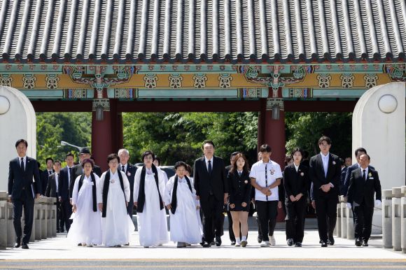 윤석열 대통령이 18일 광주시 북구 국립5·18민주묘지에서 열린 제44주년 5·18민주화운동 기념식에 참석해 5·18 유가족 대표들과 함께 ‘민주의문’을 지나 입장하고 있다. 2024.5.18 대통령실 제공