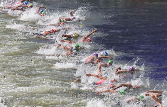 2024파리올림픽 트라이애슬론 경기가 열린 31일(현지시간) 프랑스 파리 알렉산드르 3세 다리에서 출전 선수들이 센강으로 뛰어들고 있다. 트라이애슬론 남자 경기는 30일 진행될 계획이었지만 센강 대장균 검출 수치 초과 등 수질문제로 연기됐었다. 2024.7.31 파리 박지환 기자