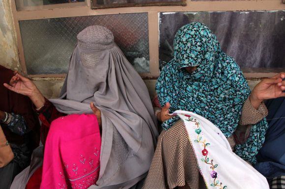 2024년 12월 28일(현지시간) 아프가니스탄 칸다하르에서 부르카(왼쪽)와 니캅을 착용한 현지 여성들이 시장에서 판매할 옷 등을 만들고 있다. 부르카는 신체 모든 부위를 가리며, 니캅은 눈만 보이도록 한 복식이다. / EPA 연합뉴스