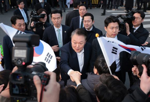 한남동 관저 앞 지지자들과 악수하는 윤석열 대통령 - 법원의 구속 취소 결정으로 서울구치소에서 석방된 윤석열 대통령이 8일 서울 한남동 관저 앞에서 차량에서 내려 지지자들과 악수하고 있다.   연합뉴스