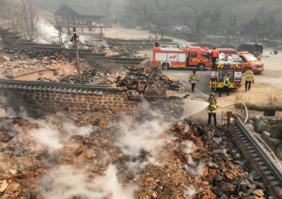 중수 작업하는 소방대원들 - 26일 경북 의성군 단촌면 고운사에서 소방대원들이 불에 탄 건물 위에 물을 뿌리고 있다. 2025.3.26 연합뉴스