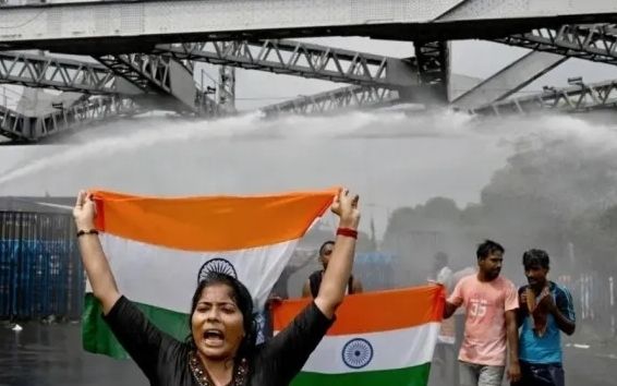 2024년 8월 27일(현지시간) 인도 서벵골주(州)에서 여성 의사가 잔혹하게 강간·살해당한 사건과 관련해 거리로 나온 시위대의 모습. 국기를 든 시위대 뒤로 경찰이 쏜 물대포가 보인다. AFP 연합뉴스