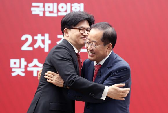 국민의힘 대선 2차 경선에 진출한 한동훈(왼쪽), 홍준표 후보가 23일 서울 영등포구 중앙당사에서 열린 2차 경선 토론회 미디어데이에서 서로를 토론 상대로 선택한 뒤 웃으며 포옹하고 있다. 2025.4.23 국회사진기자단